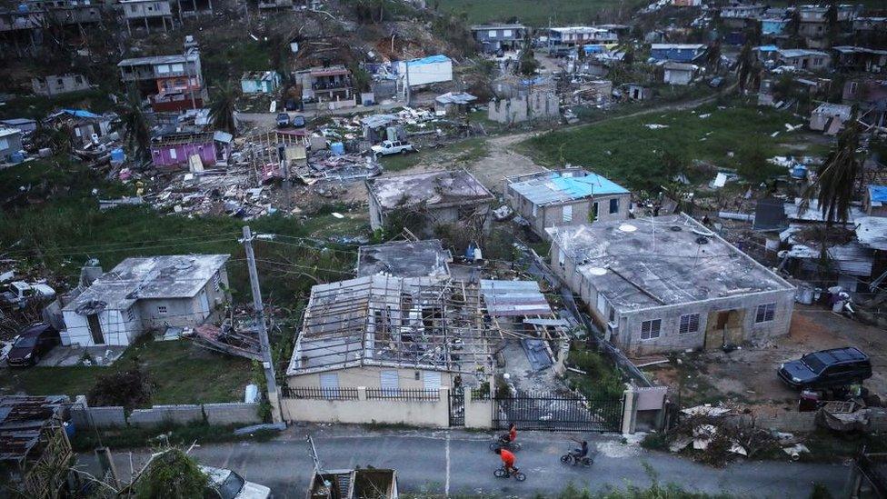 Kids bike in an area without grid power or running water about two weeks after Hurricane Maria swept through the island on October 5, 2017 in San Isidro, Puerto Rico.