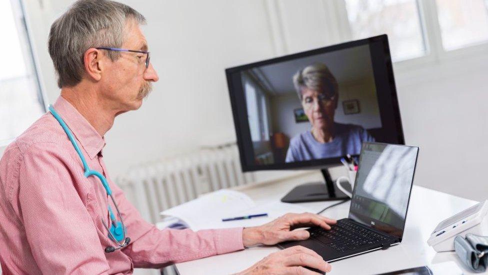 Doctor holds a medical teleconsultation with an elderly female patient.