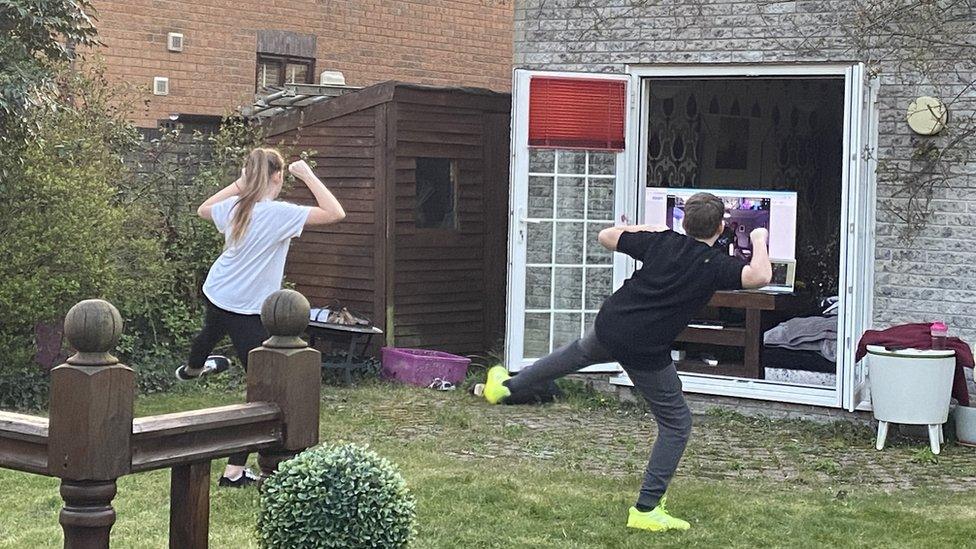 Two people doing exercise in their garden