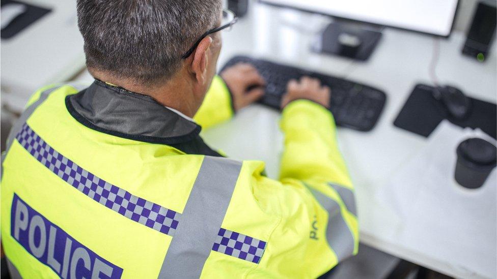 Police officer using a computer