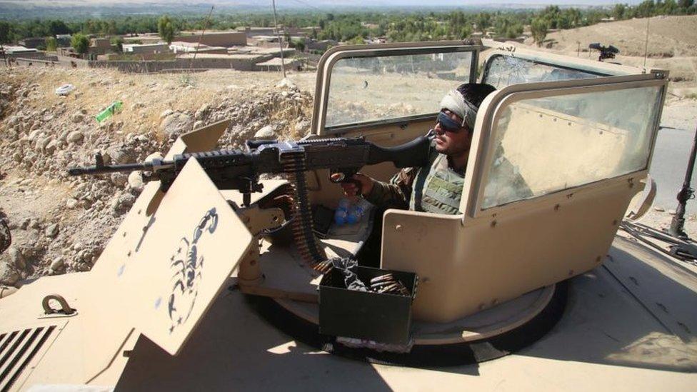 An Afghan security official stands guard at a checkpoint in Laghman province, 25 May 2021