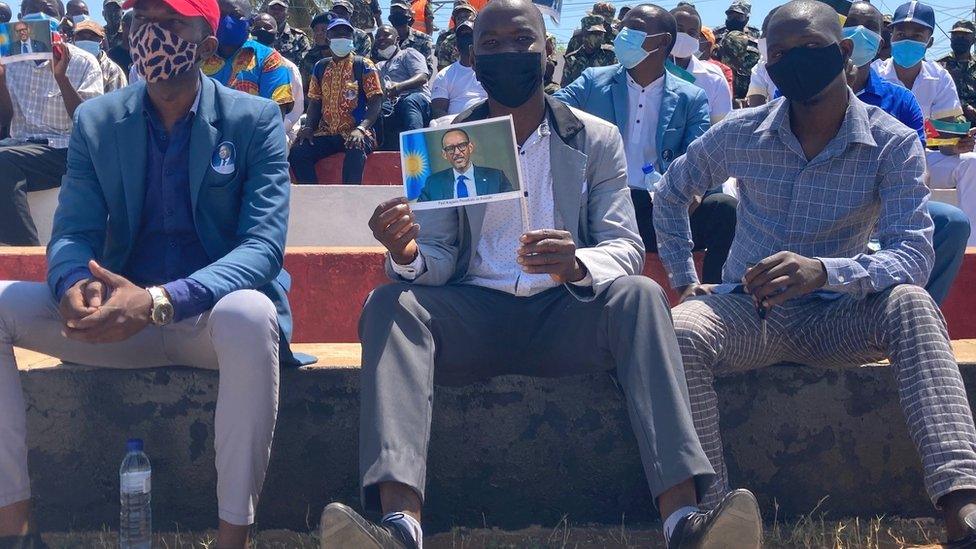 People in a crowd in Pemba hold up pictures of Rwanda's President Paul Kagame at an event to greet him during his two-day visit to Cabo Delgado in September