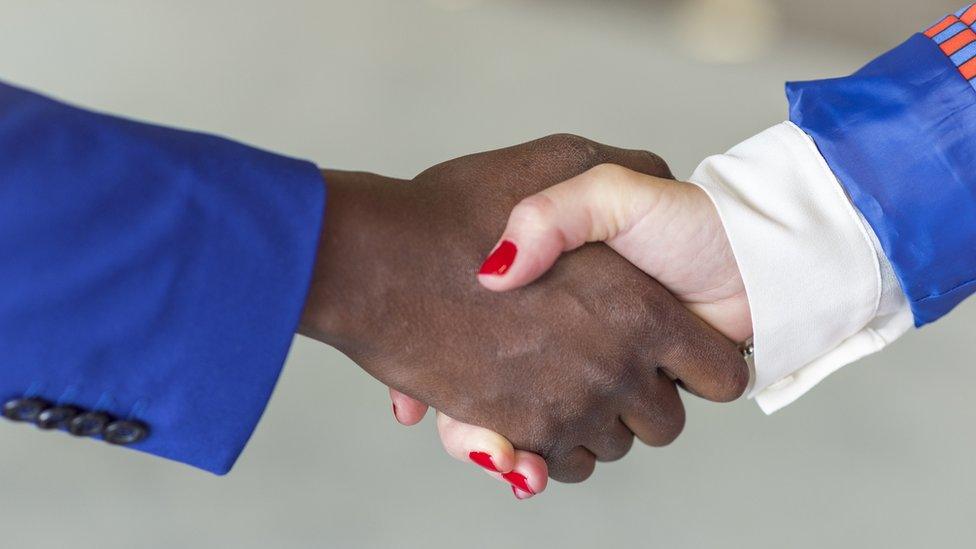 A man and a woman shake hands