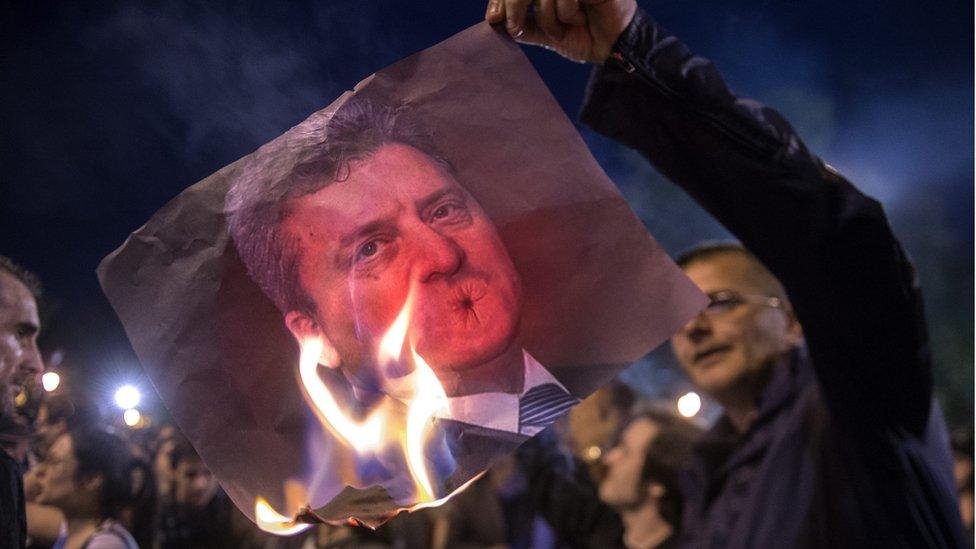 A Macedonian protester burns an image of President George Ivanov