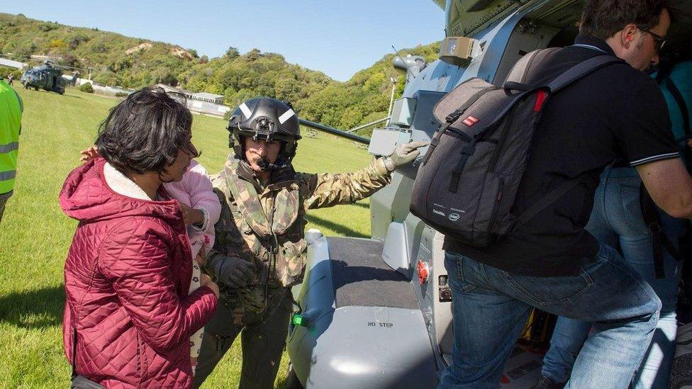 A handout photo taken and received on 15 November 2016, shows a New Zealand Defence Force helicopter evacuating some of 1,200 of tourists from Kaikoura stranded by a 7.8 earthquake that caused devastation on the east coast of the South Island.