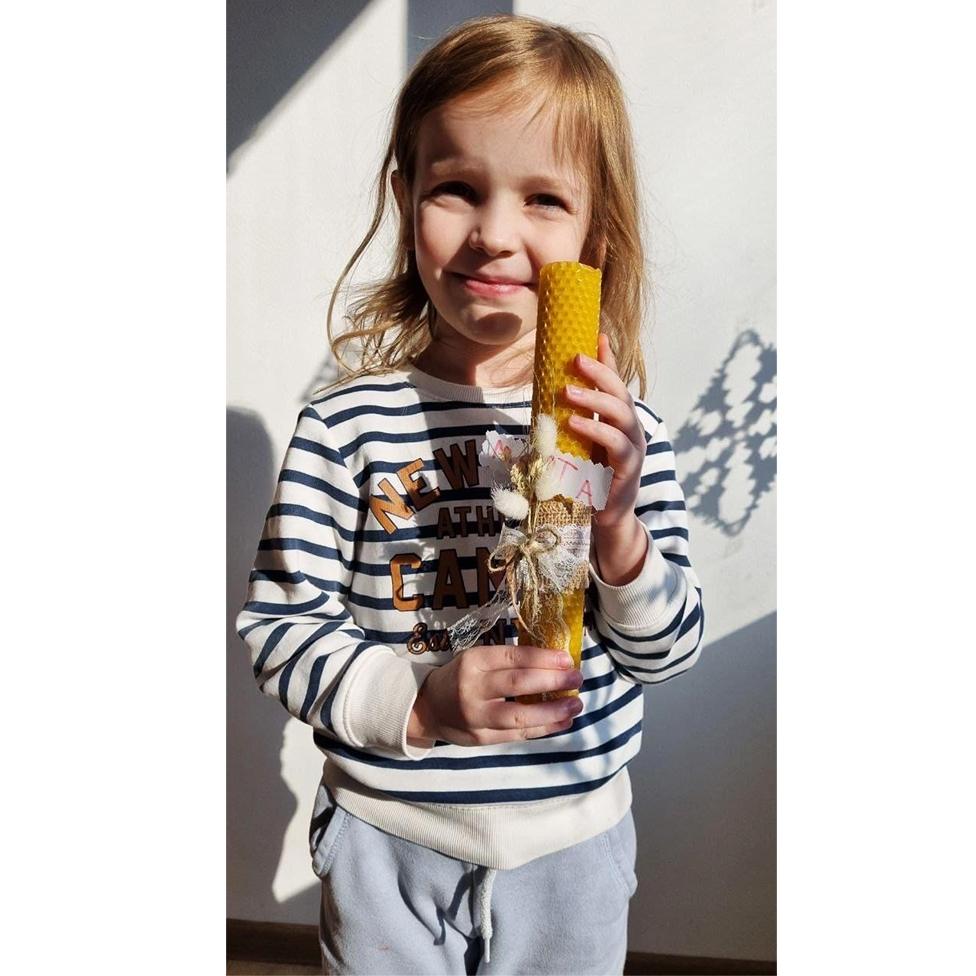 Ihor's daughter Marta holds a candle she made