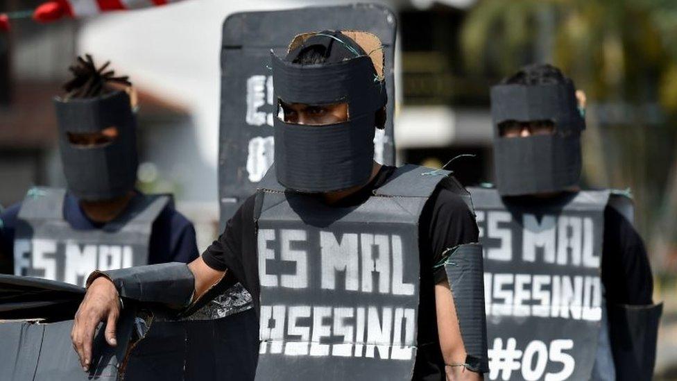 University students fancy dressed as members of the Mobile Anti-Disturbances Squadron (Esmad), demonstrate during a protest against the government of Colombian President Ivan Duque in Cali, Colombia, on December 4, 2019