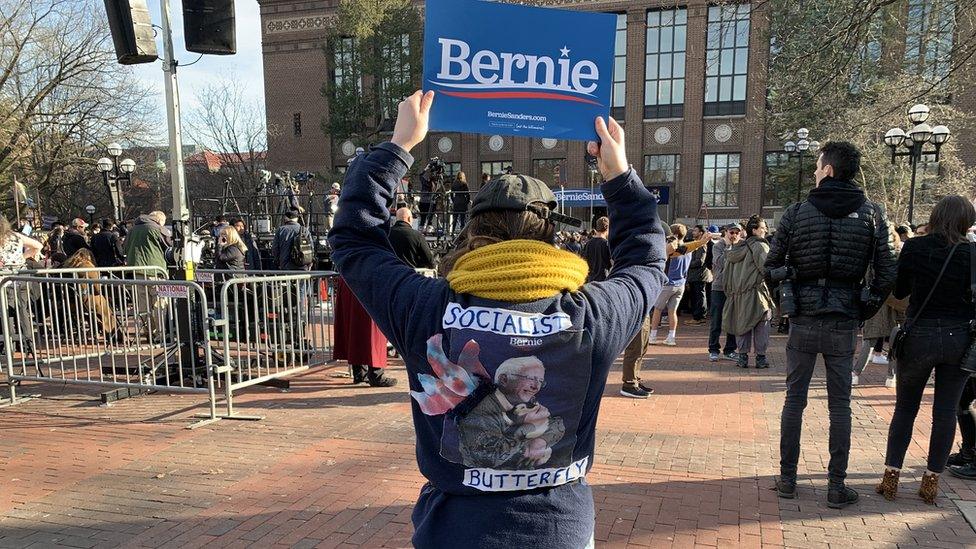 A woman at a Bernie rally holds up a sign