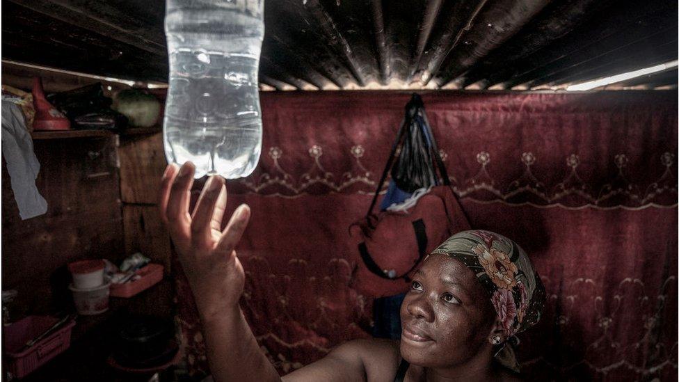 Woman starting a light coming from a bottle