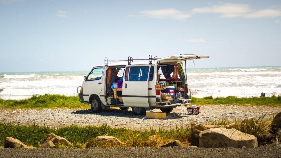 A campervan parked in a bay area by the beach