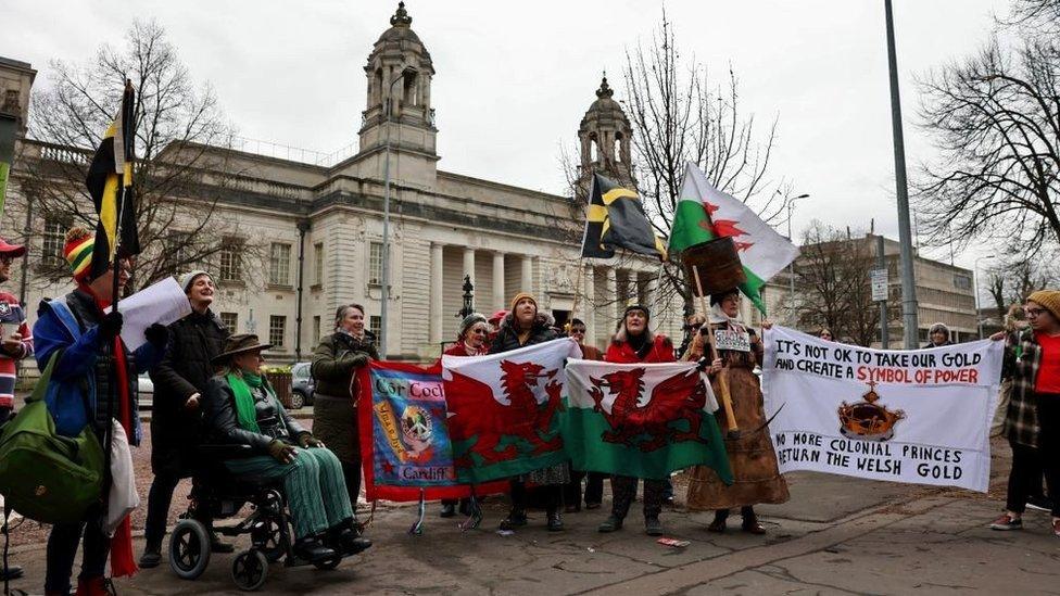 Rhai o orymdeithwyr parêd Caerdydd yn chwifio baneri Dewi Sant a Chymru o flaen Neuadd y Ddinas ar Fawrth 1 2023. Roedd y gorymdeithwyr yma yn gwrthwynebu ymweliadau brenhinol â Chaerdydd ar Ddydd Gŵyl Dewi