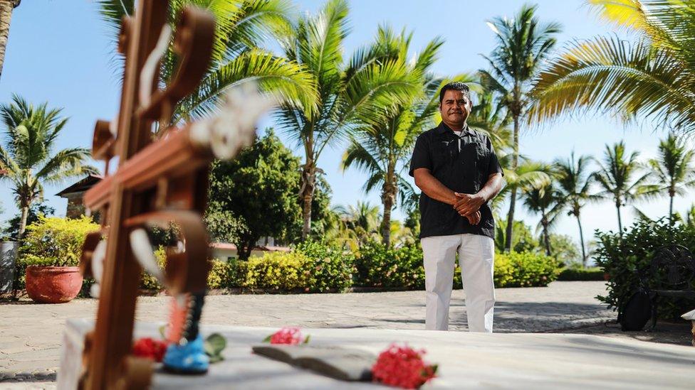 Father Marcelino Trujillo looks on at Padre Cuco's grave