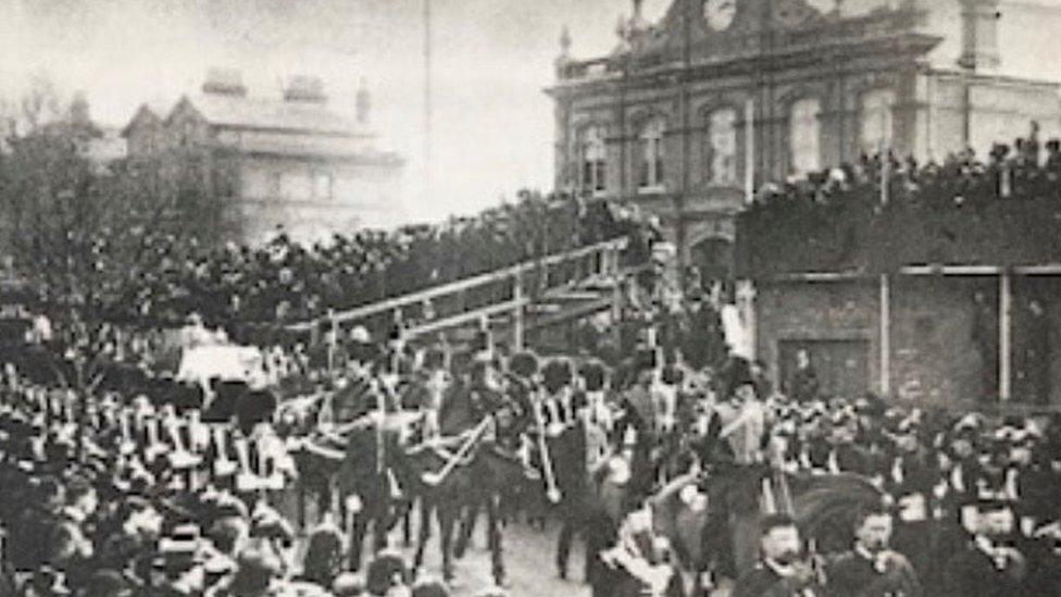 A crowd watches the procession