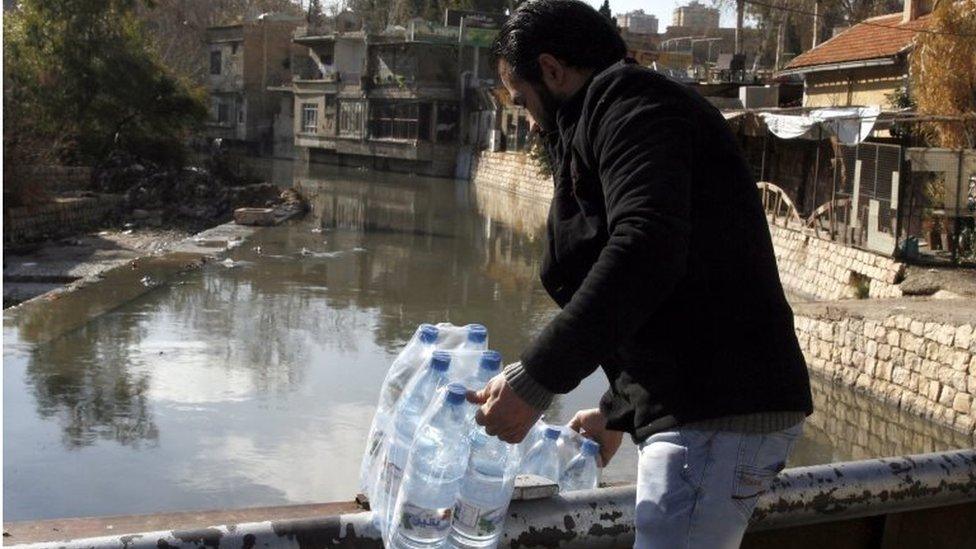 Syrian man holds bottles filled with water in Damascus, Syria, 29 December 2016.