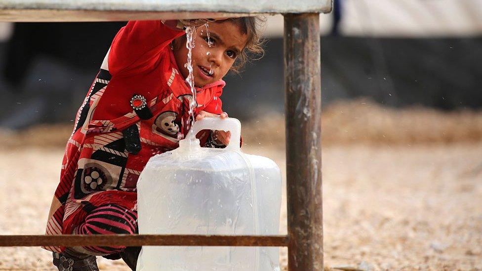 A girl getting water from a tank