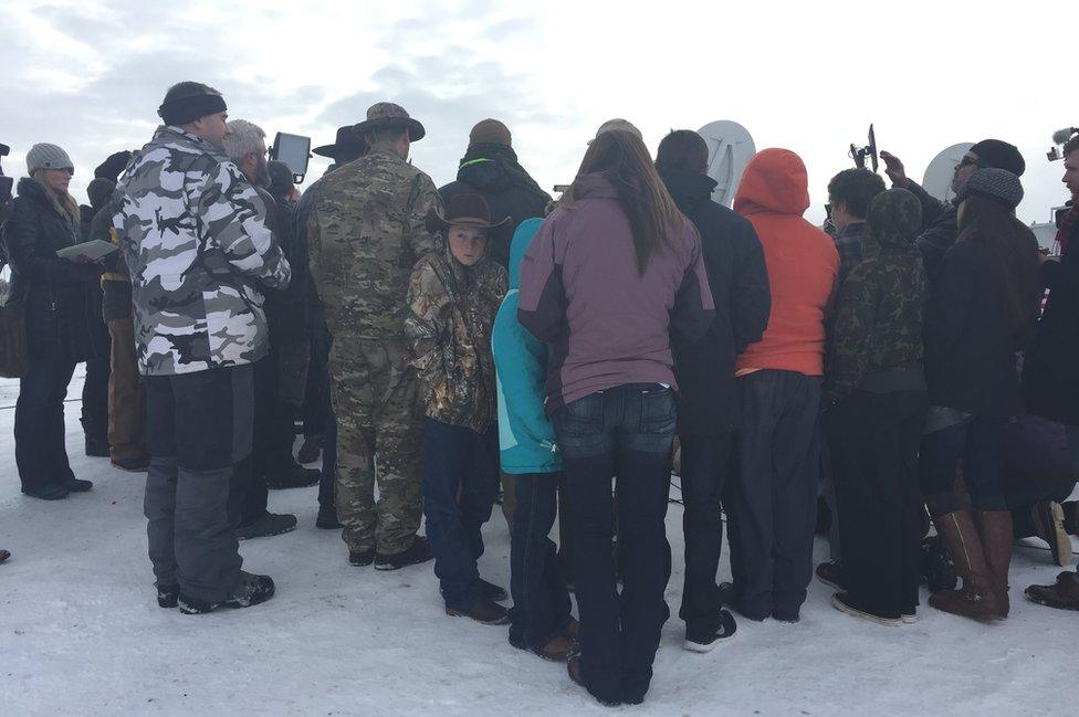 A boy attends a militia press conference with his family