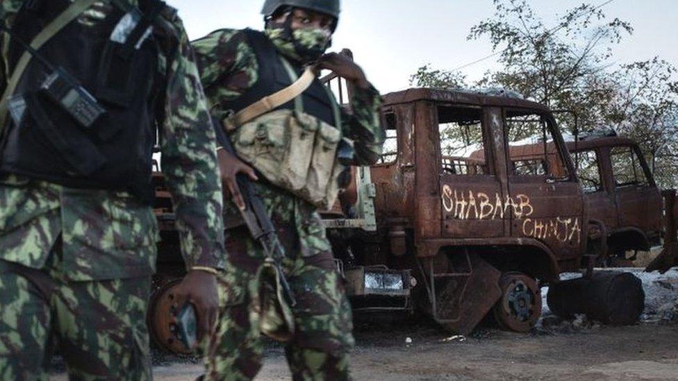 Mozambican soldiers patrol in front of a burned truck carrying the inscription "Shabaab Chinja" referring to the jihadist group in Mocímboa da Praia -22 September 2021