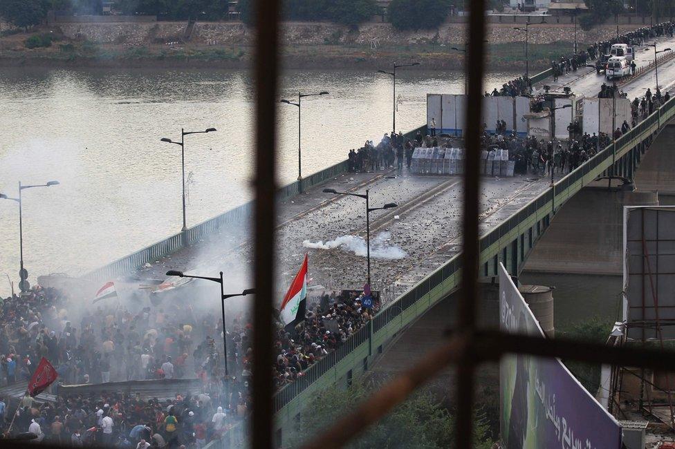 Iraqi security forces fire tear gas to stop protesters attempting to cross al-Jumhuriya bridge from Tahrir Square, Baghdad (25 October 2019)