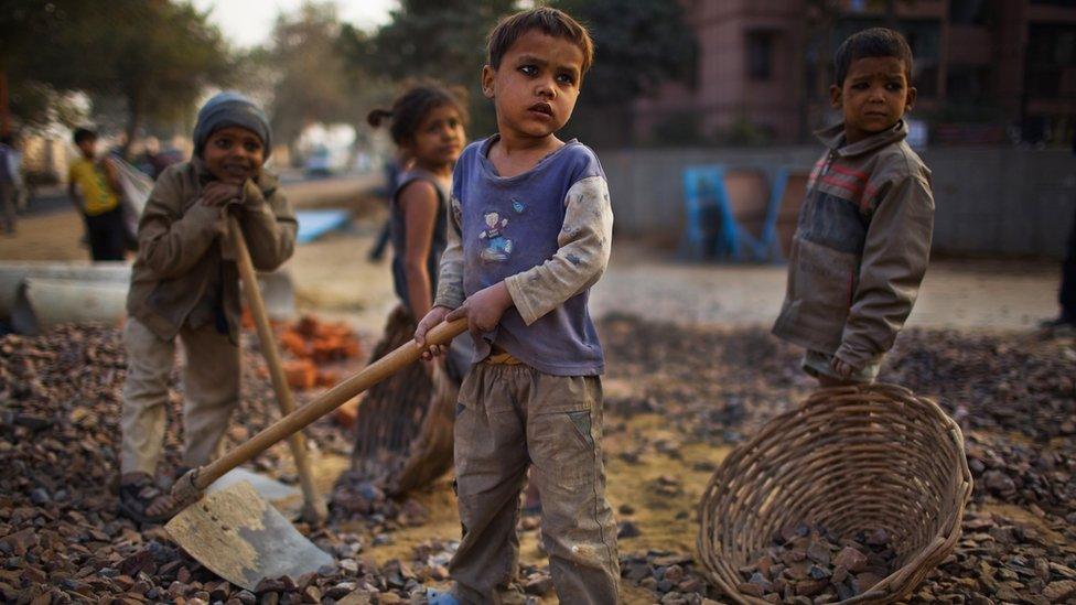 Indian children work nearby to their parents at a construction project in front of the Jawaharlal Nehru Stadium on 30 January 2010 in New Delhi, India