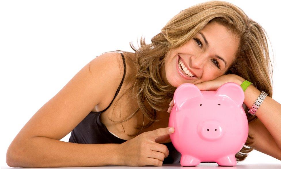 Woman leans on piggy bvank