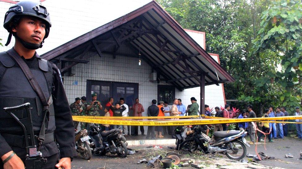 A soldier stands guard outside the Church's compound