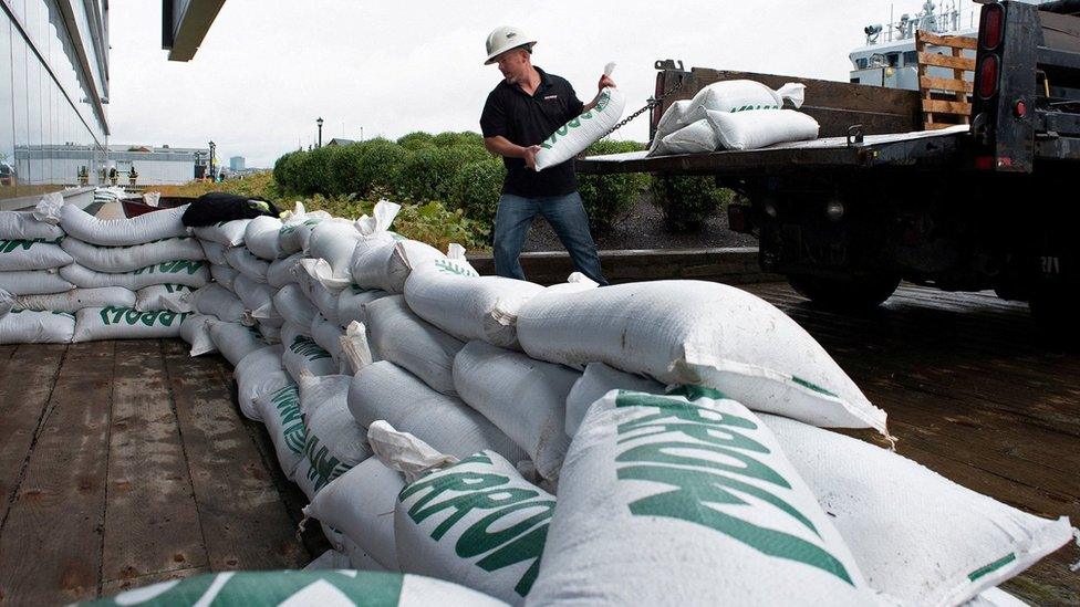 A man puts sandbags in front of a door