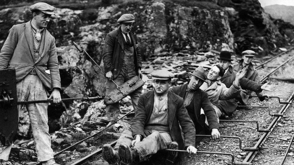 Photo of quarrymen using the rail lines to slide down towards home