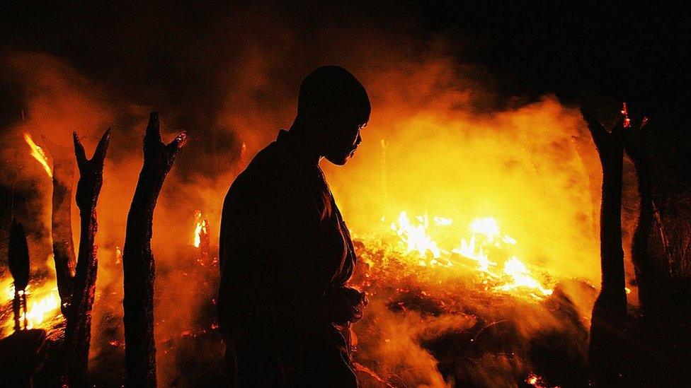 A Sudanese rebel fighter from the Justice and Equality Movement (JEM) sombrely watches the abandoned village of Chero Kasi burn less than an hour after Janjaweed militiamen set it ablaze in the violence plagued Darfur region September 7, 2004.