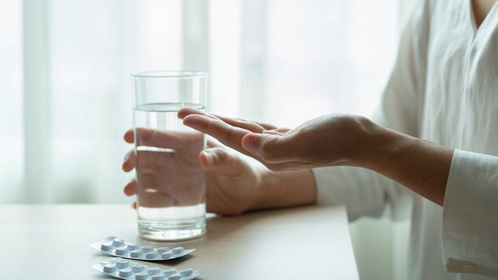 Woman taking pills, file pic