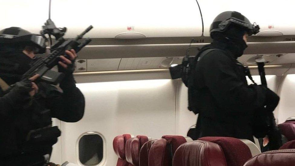 Heavily armed police enter the plane after it returned to Melbourne Airport