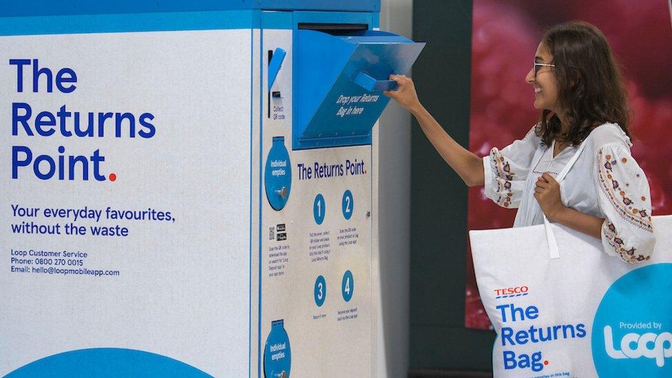 A shopper visiting the Loop collection point at a Tesco supermarket aisle