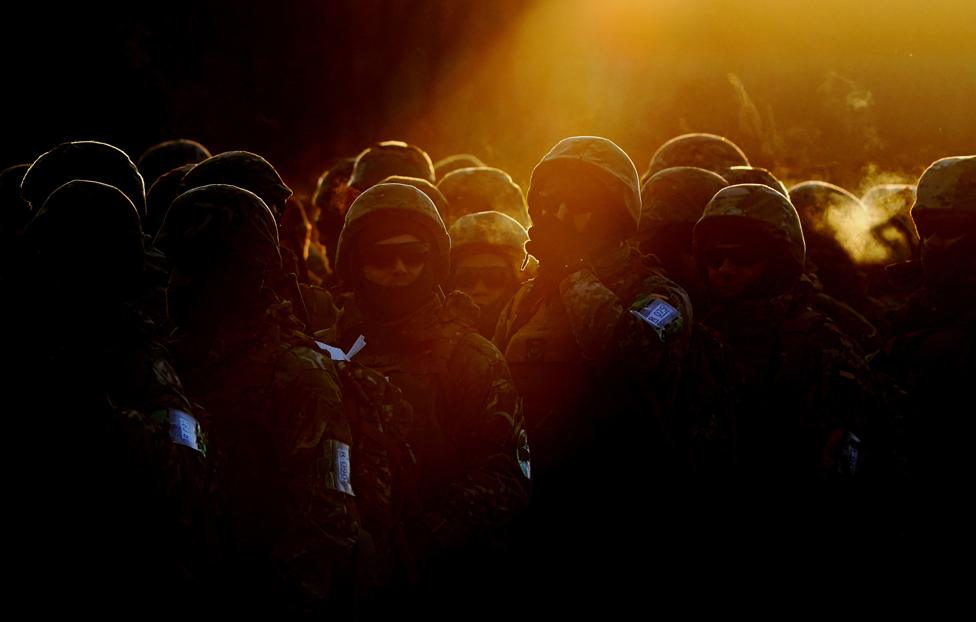 Ukrainian troops and their UK military instructors, commemorate lives lost in the Russian invasion of Ukraine during a sunrise commemorative service, at Lydd army camp in Kent, to mark the one-year anniversary of the start of the conflict.