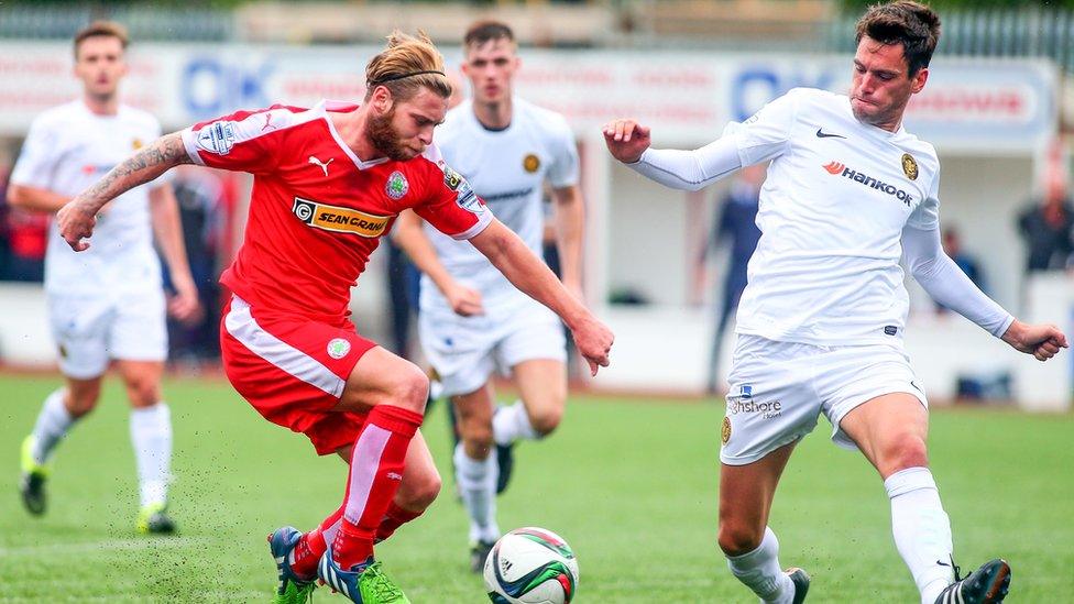 Cliftonville's James Knowles and Mark Surgenor of Carrick Rangers in action at Solitude