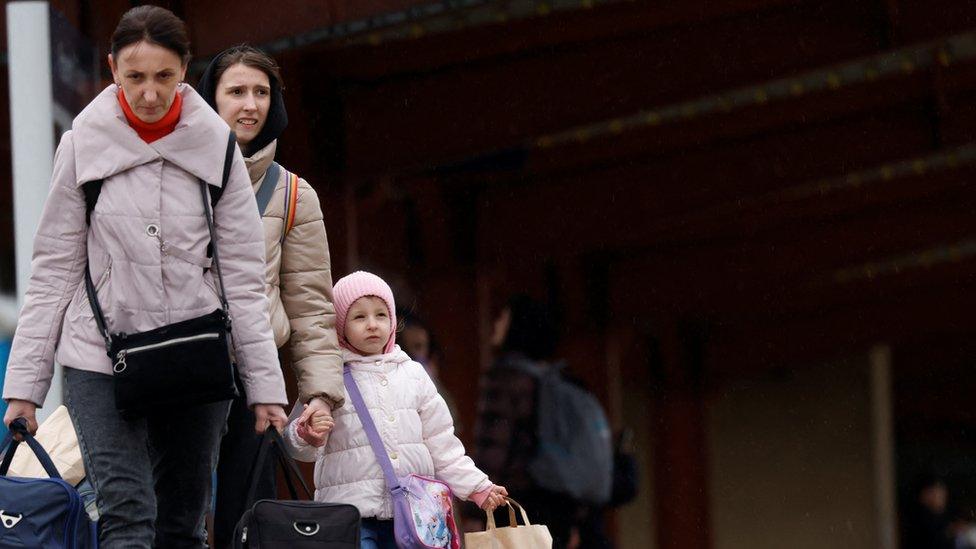 Ukrainian refugees fleeing the Russia"s invasion of Ukraine walk on the platform after arriving on a train from Odesa at Przemysl Glowny train station, in Poland,