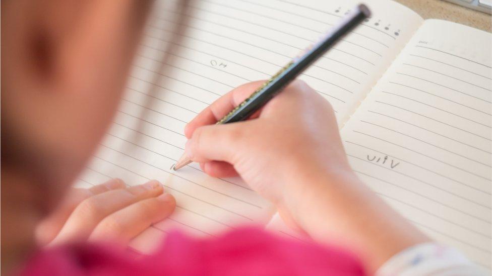 A young girl learns to write at pre-school