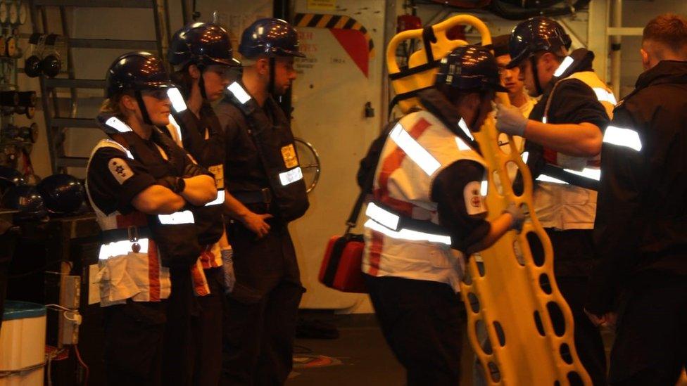 Sailors from HMS Diamond get ready to launch the vessel's sea boat to help the yacht