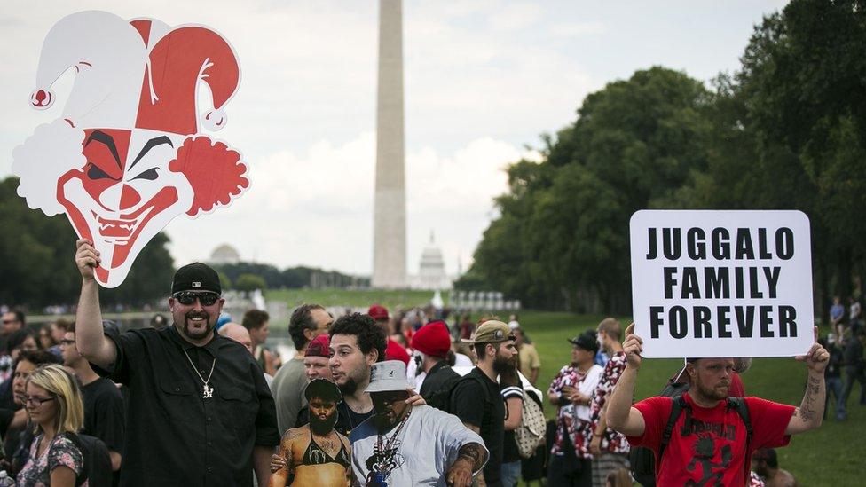 A man holds up a giant cut out of a clown face during the rally in Washington