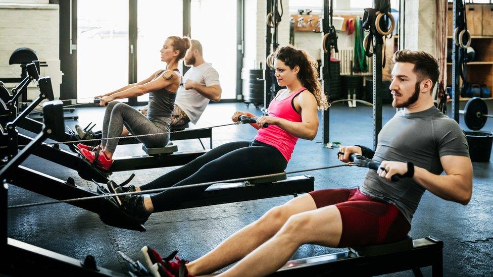 Gym goers on rowing machines