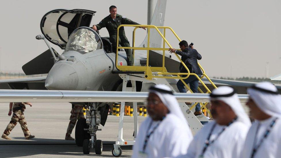 Emiratis walk past a French Rafale fighter jet displayed during the Dubai Airshow on November 14, 2017, in the United Arab Emirates.