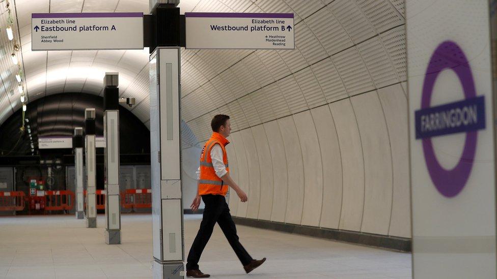 A Crossrail employee walks in the new Farringdon underground station of the Elizabeth line