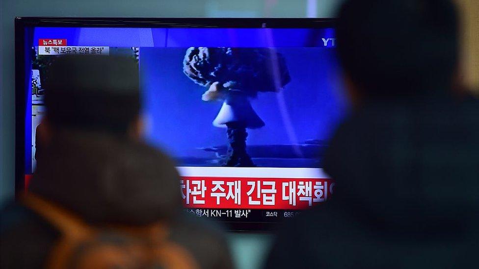 People watch a news report on North Korea's first hydrogen bomb test on 6 January 2016