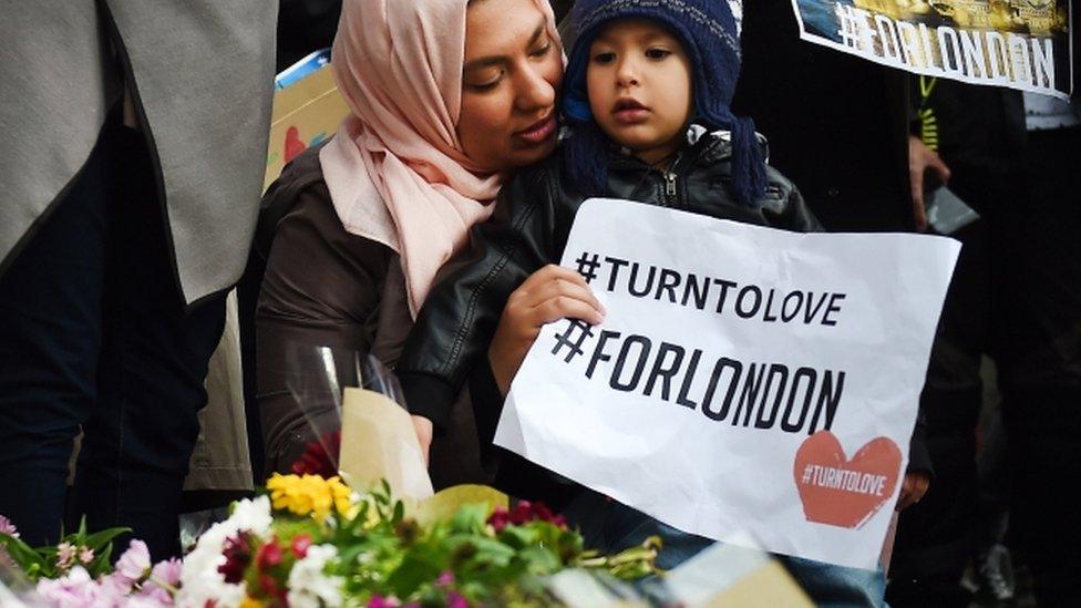 Members of London's Muslim community hold signs of condolence and support near the site of an attack at Borough Market in London