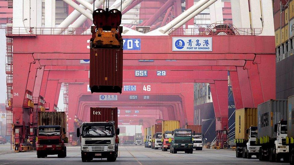 A container is lifted by a crane at a port in Qingdao, east China's Shandong province