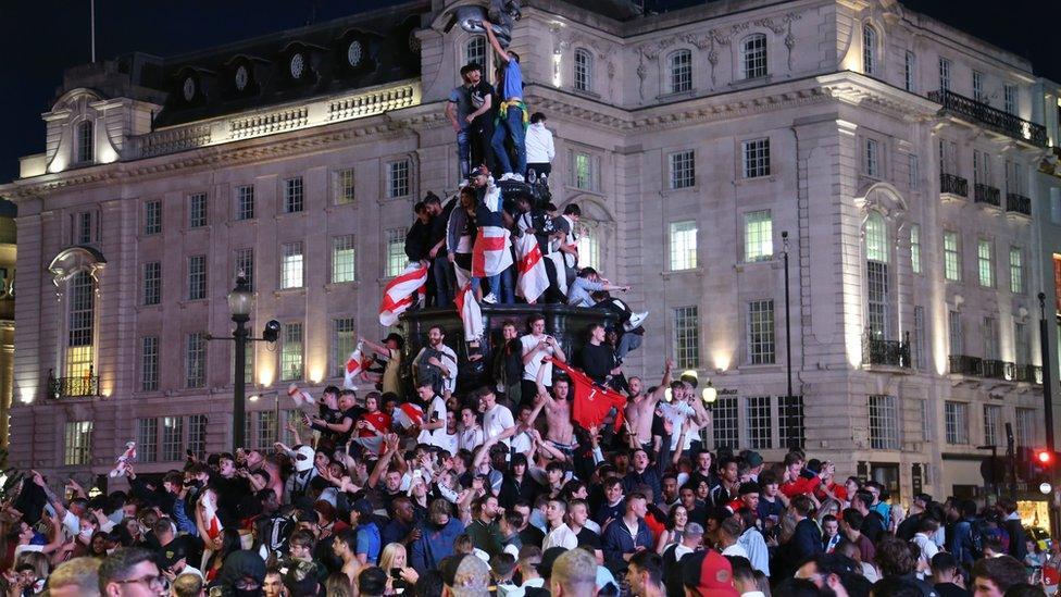 England fans climb on the the Shaftesbury Memorial Fountain, in Piccadilly Circus