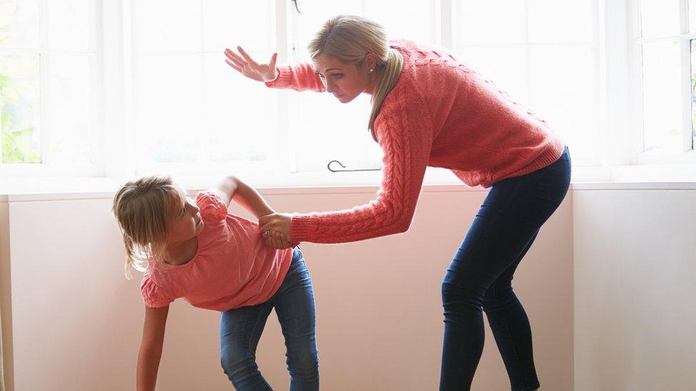 Mother raising her hand to her daughter