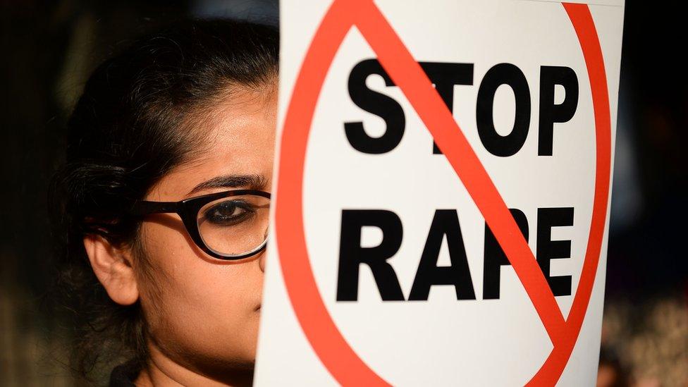 An Indian social activist holds a placard during a protest against a rape at Hauz Khas village in New Delhi on February 21, 2017