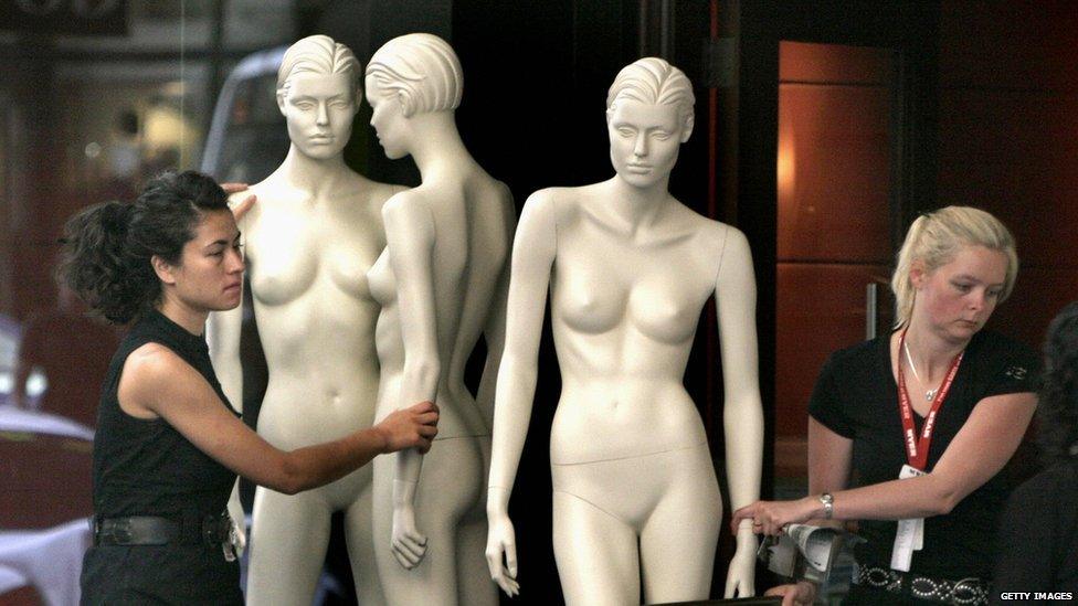 Women moving shop mannequins