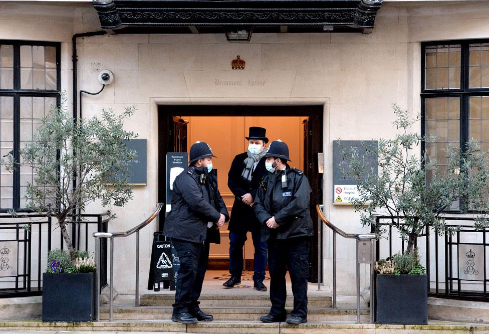 Police officers stand outside an entrance to the King Edward VII Hospital in London