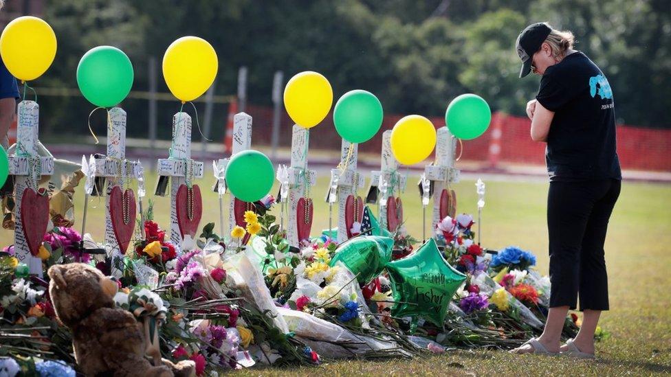 Mourners visit a memorial in front of Santa Fe High School on May 22, 2018