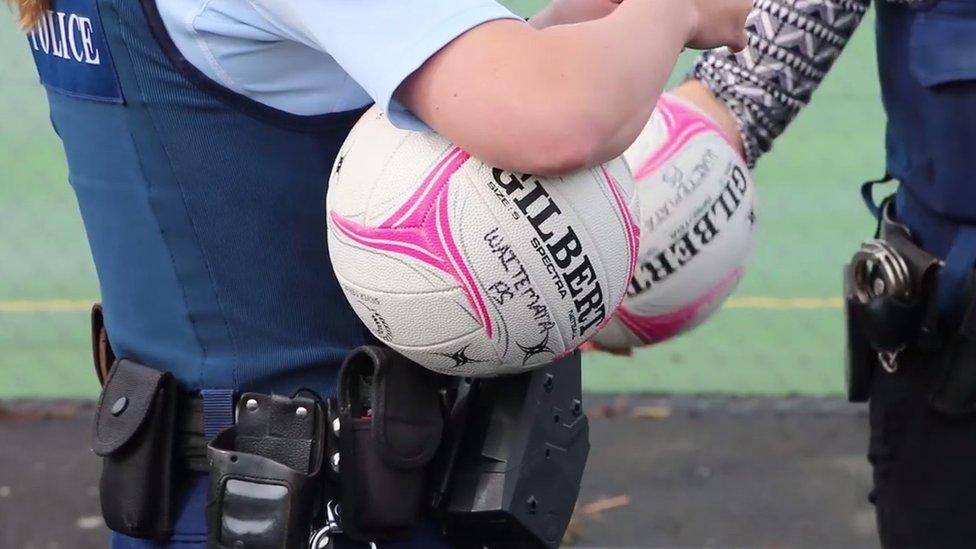 A police officer holding a netball ball